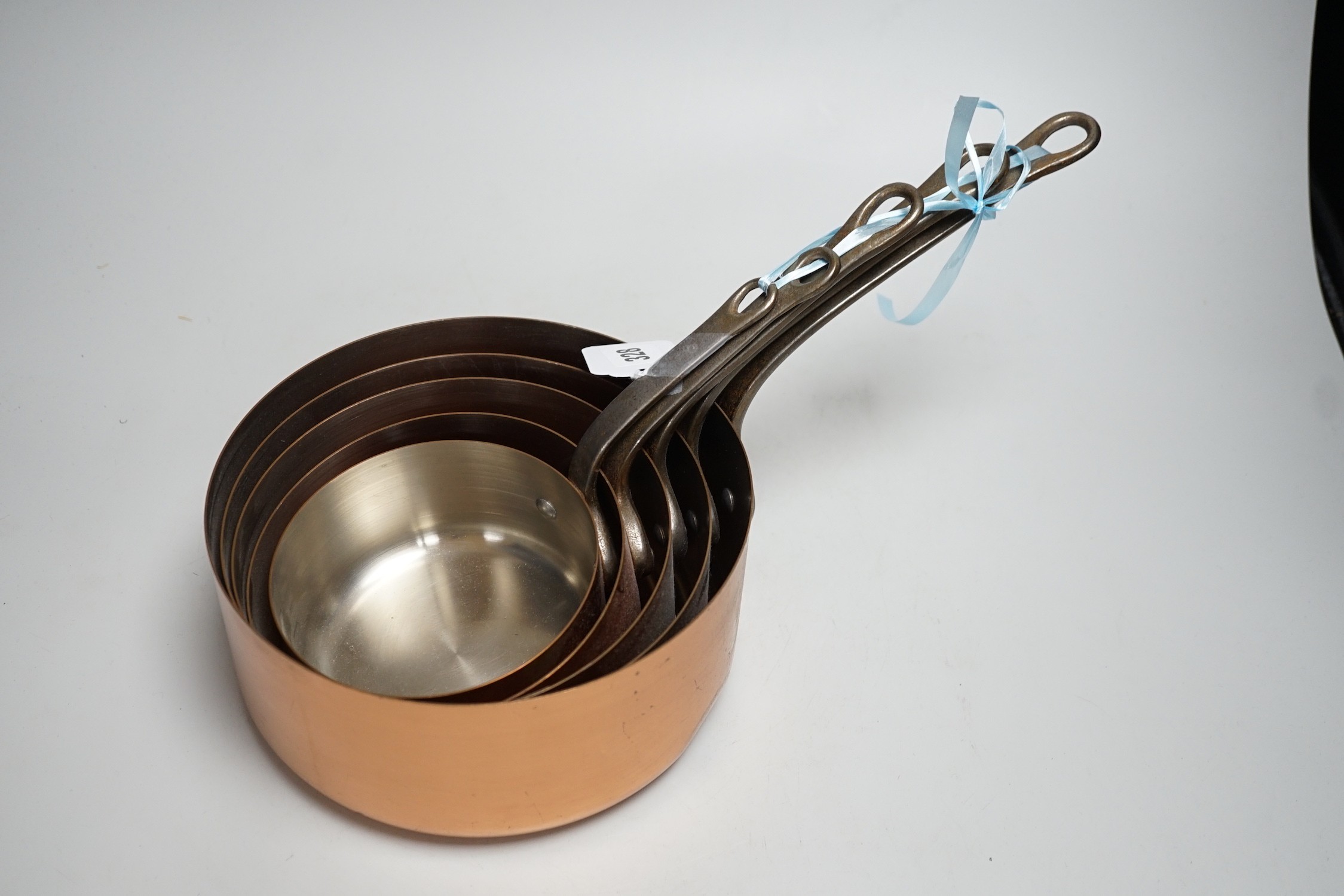 A set of French graduated copper saucepans, batterie de cuisine